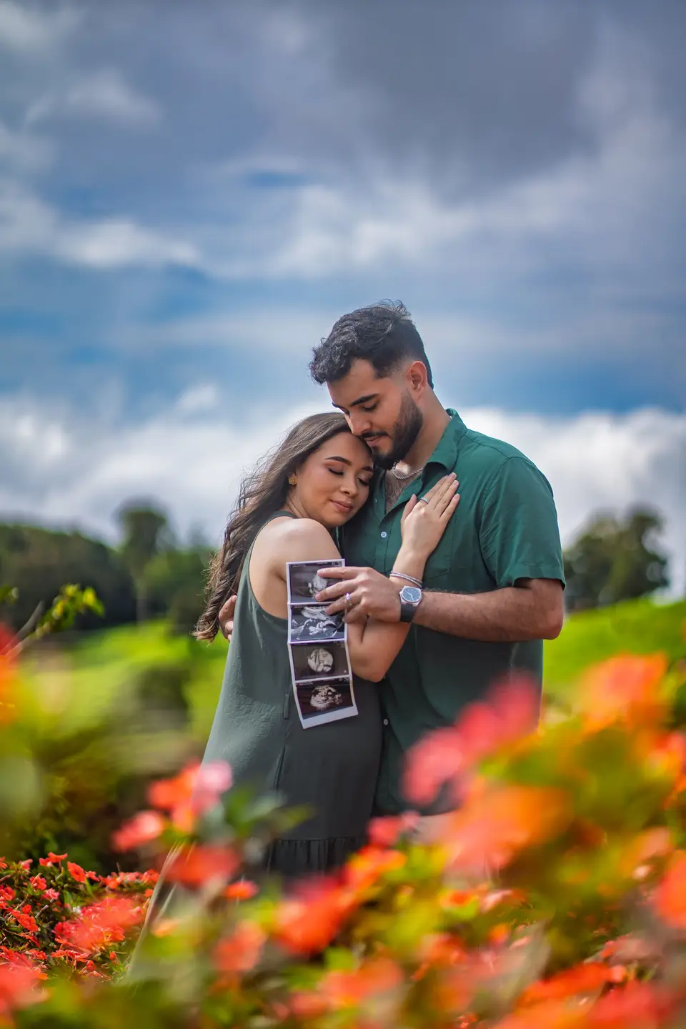Pareja con ultrasonido en jardín de flores